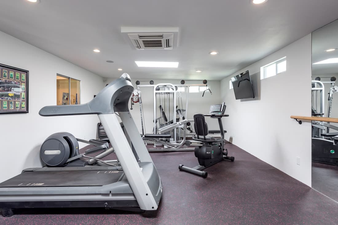 Exercise room with treadmill, weights and mirrored wall