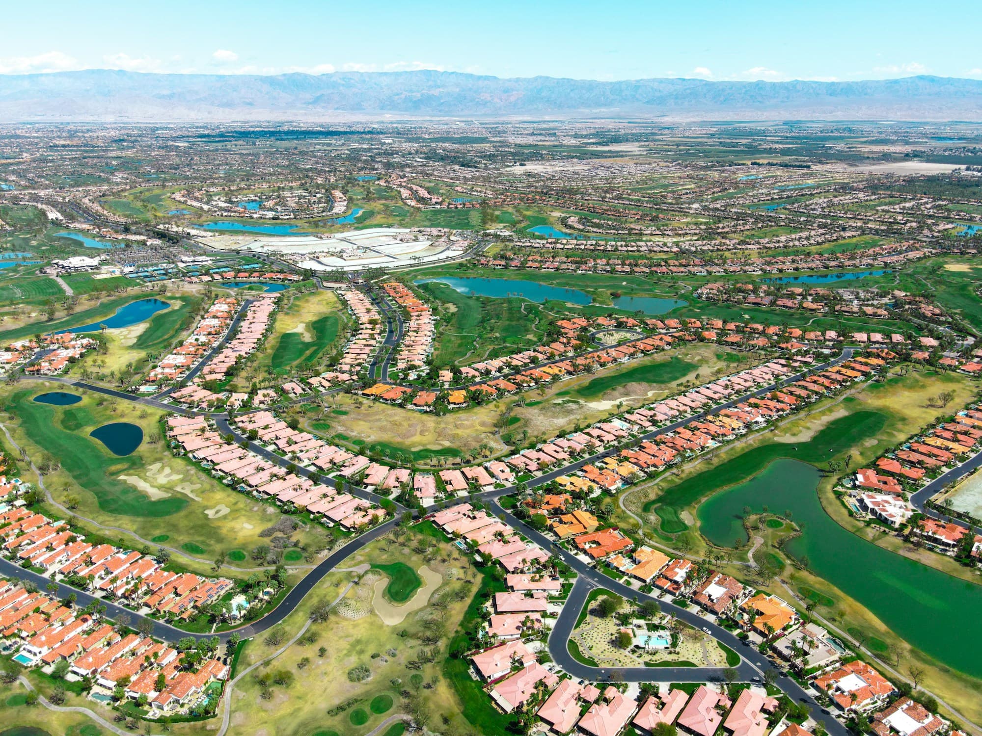 Aerial over La Quinta's golf communities, fairways and water hazards winding between the homes