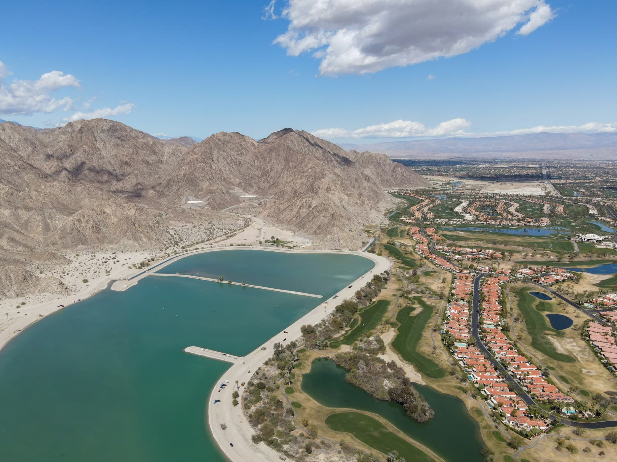 Aerial of Lake Cahuilla in La Quinta, with golf courses running along the foot of the Santa Rosa Mountains