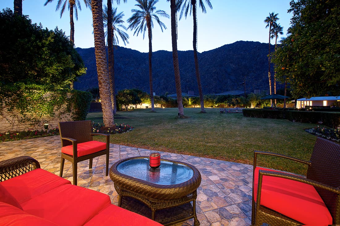 Patio table and red chairs looking toward mountains at dusk